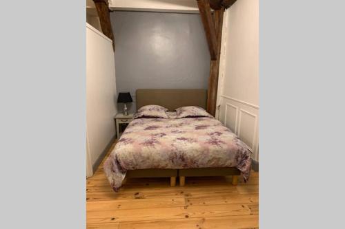 a bedroom with a bed with a blanket on it at Appartement entre Paris et CDG in Écouen