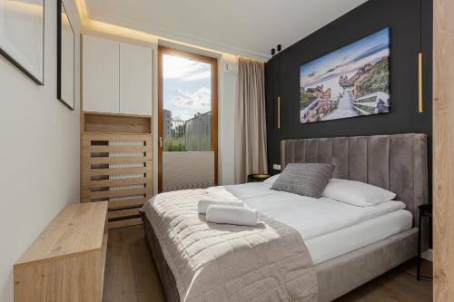 sypialnia z dużym łóżkiem i dużym oknem w obiekcie Apartment Forest Club Kabaty by Renters Prestige w Warszawie