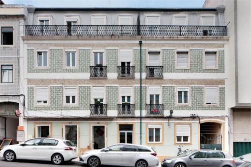 two cars parked in front of a large building at Cosy Room in Alcantara - Lisboa in Lisbon