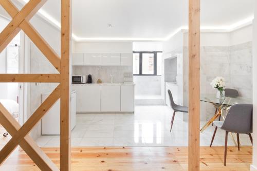 a kitchen and dining room with white cabinets and a table at Cosy Room in Alcantara - Lisboa in Lisbon