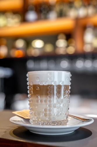 a coffee cup sitting on a plate on a table at Hotel Mrak in Ljubljana