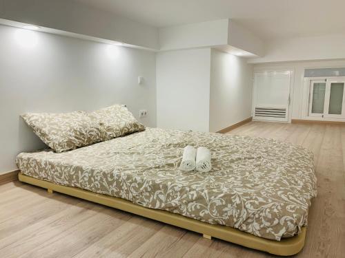 Un dormitorio con una cama con dos zapatos. en Piso céntrico y funcional, en Madrid