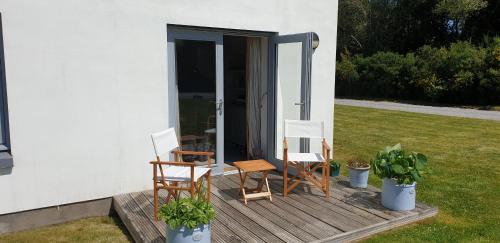 two chairs and a table on a wooden deck at One The Cairns in Connel