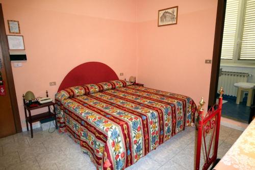 a bedroom with a bed with a colorful bedspread at Hotel Italia in Turin