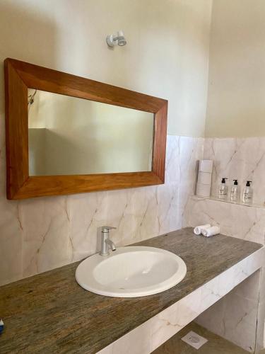 a bathroom with a sink and a mirror on a counter at Paje Beach Apartments & Hotel in Paje