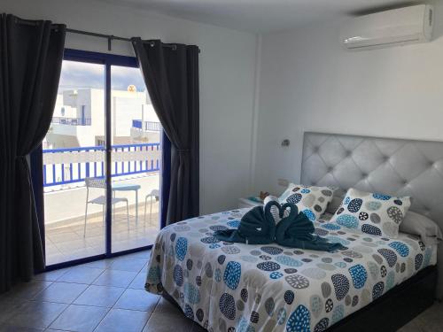 a bedroom with a bed with a view of a balcony at Villa Maria in Playa Blanca