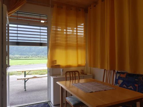 a kitchen with a table and a yellow curtain at Kleblach 90, 9753 Lind im Drautal in Kleblach