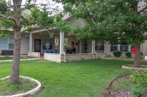 a house with a yard with two trees in front of it at Hill Country Haute n Haus Relax and Renew in Fischer
