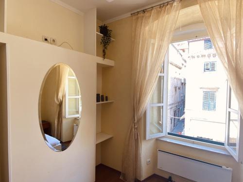 a room with a mirror and a window at Apartment Tomasović Old Town in Dubrovnik
