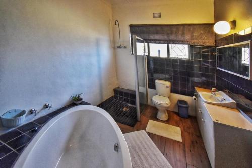 un bagno con vasca, WC e lavandino di The Orchid Guesthouse a Bethlehem