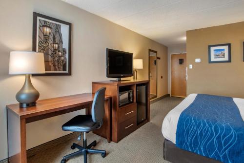 a hotel room with a bed and a desk with a computer at Comfort Inn Shady Grove - Gaithersburg - Rockville in Gaithersburg