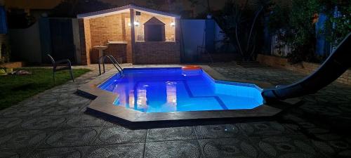a swimming pool in a yard at night at Blue House in Alexandria