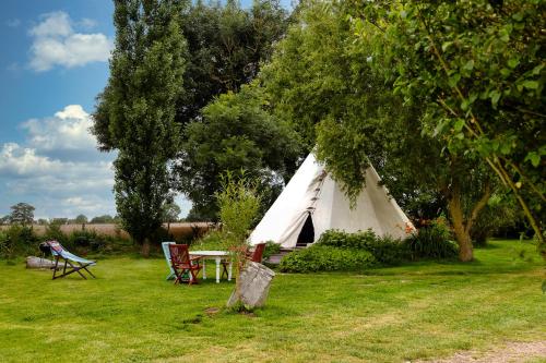 a white tent with a table and chairs in a field at Au Bonheur Nomade in Livry