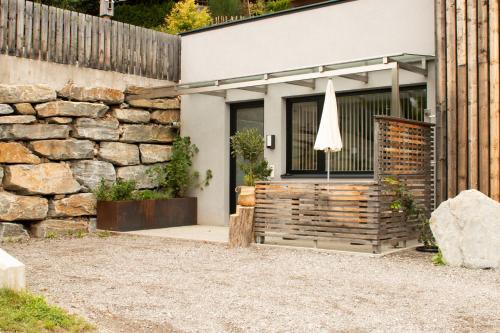 a house with a stone wall and an umbrella at Hochsitz Schladming in Schladming