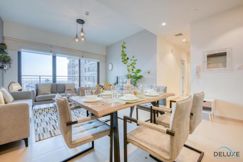 a dining room and living room with a table and chairs at Community Living 2BR Close to Emirates Golf Club, Golf Views A, Madinat Al Mataar by Deluxe Holiday Homes in Dubai