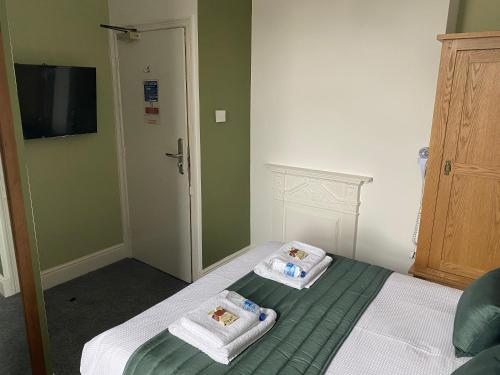 a bedroom with a bed with two towels on it at The Promenade Guest House in Bridlington