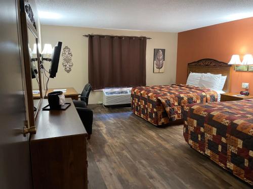 a hotel room with two beds and a television at Southfork Motel in Bloomfield