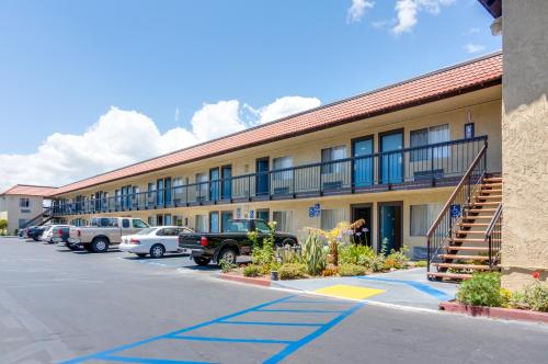 a building with cars parked in a parking lot at Motel Moonlight in Anaheim