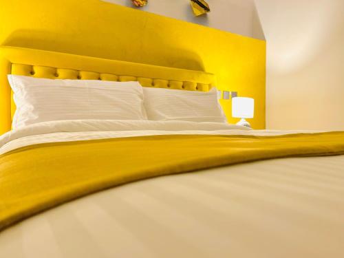 a yellow bedroom with a bed with a yellow headboard at Casa Reale Boutique Hotel in Valletta