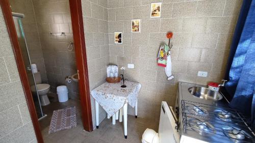 a small bathroom with a table and a sink at Chalés Vila da Serra in Serra Negra