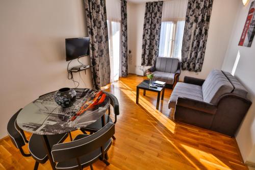 a living room with a table and a couch at Apartmani Nica in Sveti Stefan