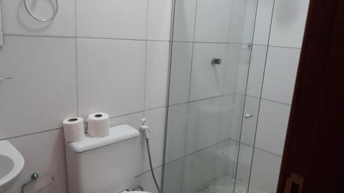 a bathroom with a glass shower stall and a toilet at Pousada Pedra do Sossego in Triunfo