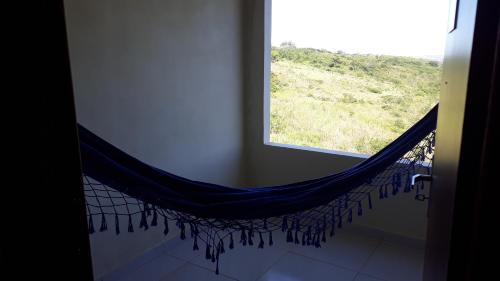 a hammock in front of a window in a room at Pousada Pedra do Sossego in Triunfo