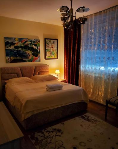 a bedroom with a large bed and a window at Unique Traditional House, hosted by J&G in Tirana