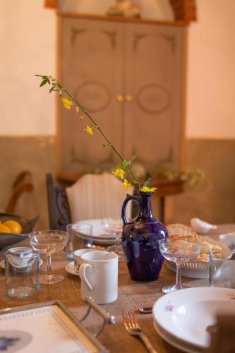 a table with a blue vase with yellow flowers in it at La Magione dei Todaro in Borgo a Buggiano