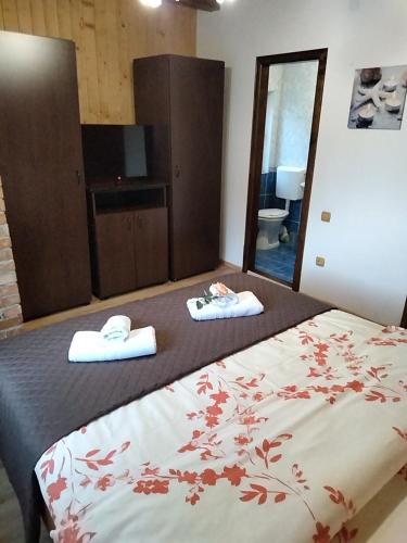 a bedroom with a bed with towels on it at Dor de Munte Transfăgarasan in Cîrţişoara