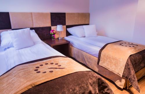 a bedroom with two beds and a table with flowers at Boutique Hotel's III Piłsudskiego in Łódź