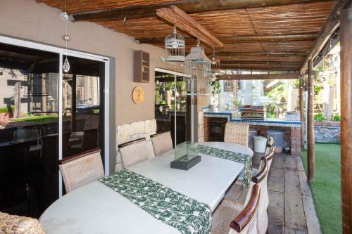 a table and chairs on a patio with a table and a table at Strand Guesthouse in Strand