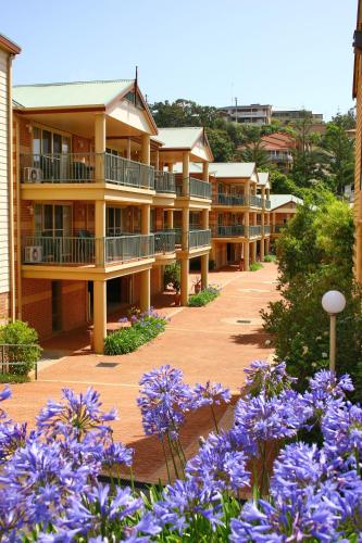 a row of apartment buildings with purple flowers at Terralong Terrace Apartments in Kiama