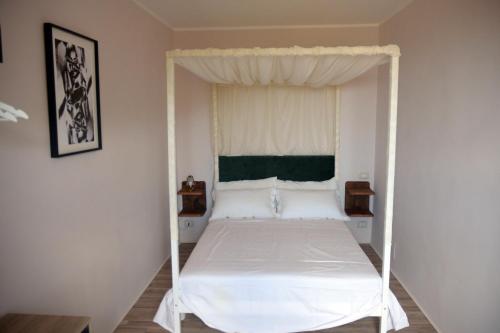 - une chambre avec un lit blanc à baldaquin dans l'établissement "Le pietre silenti" antica dimora del 1300', à Nerola