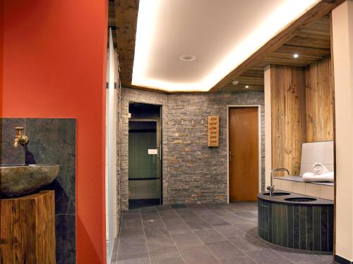 ein Badezimmer mit orangefarbener Wand und Waschbecken in der Unterkunft Sunstar Hotel Klosters in Klosters