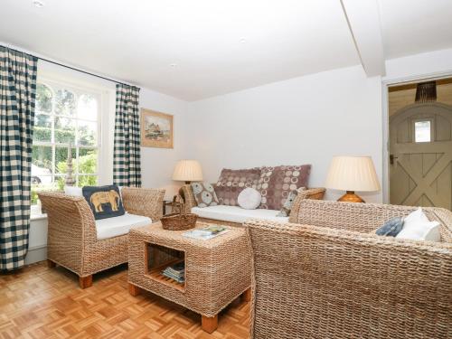 a living room with wicker chairs and a couch at Downton Lodge in Lymington