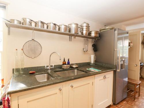 a kitchen with a sink and a refrigerator at Downton Lodge in Lymington
