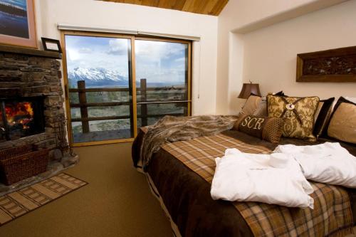 een slaapkamer met een bed, een open haard en een raam bij Spring Creek Ranch in Jackson