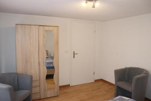 a room with a door with a mirror and two chairs at Royal Swiss Apartments in Ringgenberg