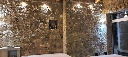 eine Steinmauer in einem Zimmer mit einem Tisch und Stühlen in der Unterkunft Il Tufo in Montesano sulla Marcellana