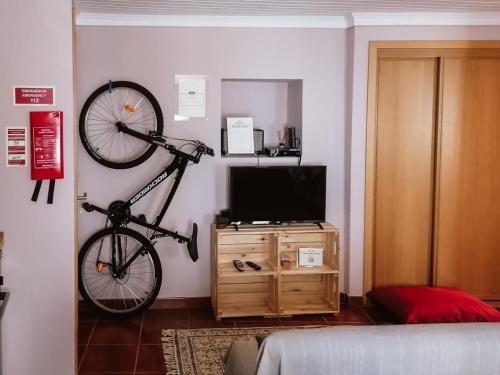 una bicicletta appesa a un muro in una stanza di Casa Augusta - The Natural Lodgings And Retreats a Águas de Verão