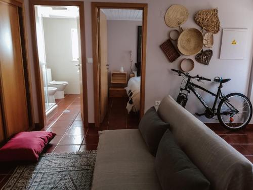 a living room with a couch and a bike on the wall at Casa Augusta - The Natural Lodgings And Retreats in Águas de Verão