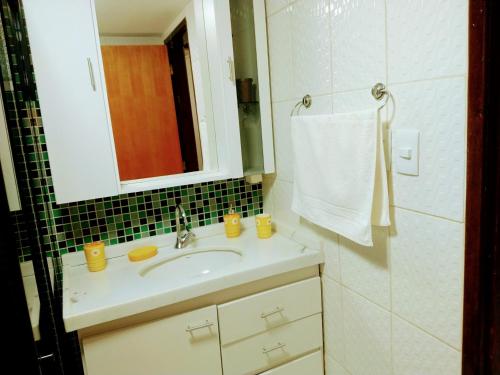 a bathroom with a sink and a mirror at Apartamento na Praia de Ponta Verde a 300mt da praia in Maceió