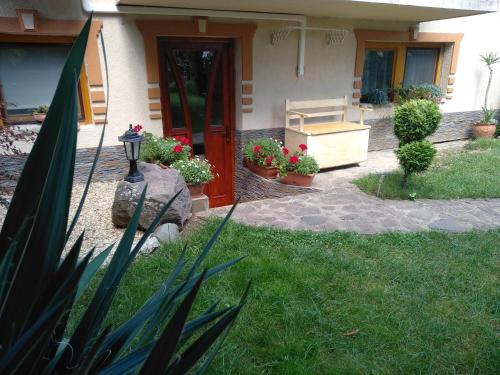 a house with potted plants and a red door at Margaréta Panzió in Sárospatak