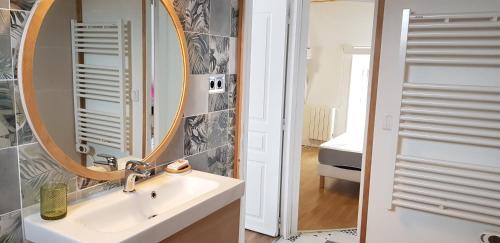 uma casa de banho com um lavatório e um espelho em Gîte Lucian Mont-saint-michel em Moidrey