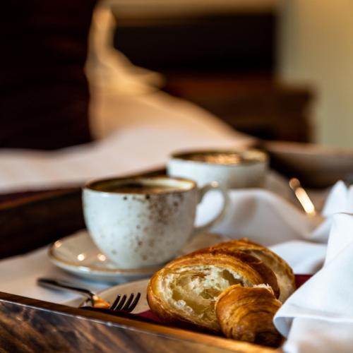 two cups of coffee and bread on a tray at Casa Hotel in Chesterfield