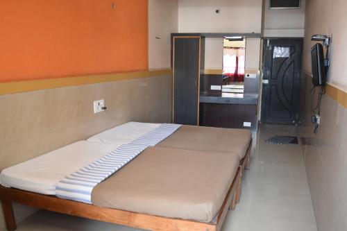Säng eller sängar i ett rum på Hotel Abhiruchi Lodging
