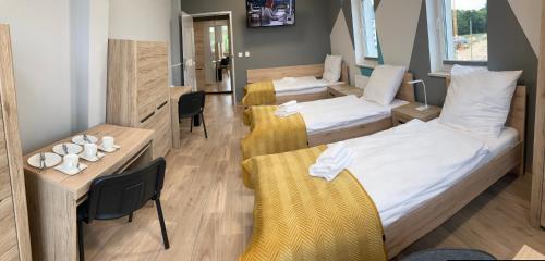 a hotel room with two beds and a table at Hullo in Lubawa