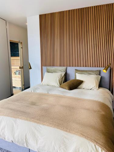 uma cama grande com duas almofadas em cima em Lit de Clémot em Merelbeke