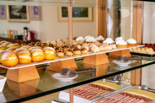 a display case filled with lots of donuts and pastries at Pousada Dreams in Campos do Jordão
